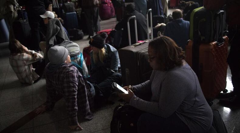 Passengers wait for the lights to come back on at Hartsfield-Jackson International Airport Sunday, December 17, 2017. The Airport is reporting a loss of electricity. The FlightAware site reports the airport is currently holding all. (Photos: Steve Schaefer/The Atlanta Journal-Constitution)