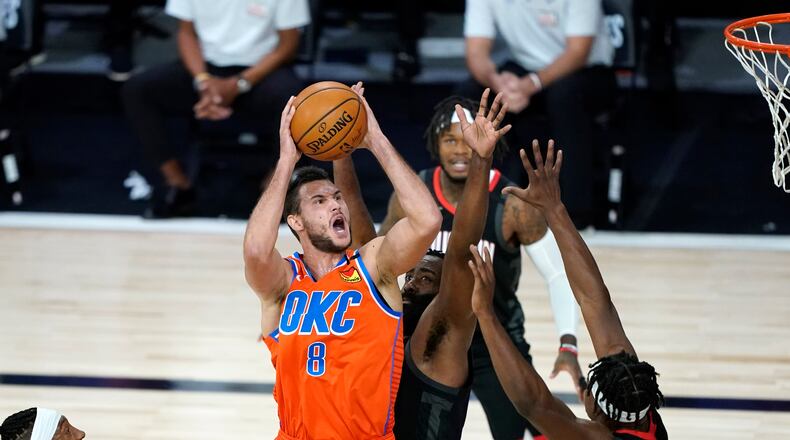 Oklahoma City Thunder's Danilo Gallinari (8) goes up for a shot as Houston Rockets' James Harden, center, and Danuel House Jr. (4) defend during the first half of an NBA basketball first round playoff game Saturday, Aug. 29, 2020, in Lake Buena Vista, Fla. (AP Photo/Ashley Landis)