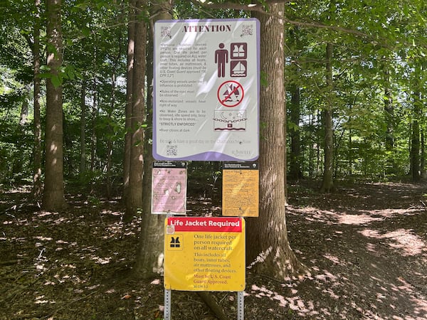 Signs warn visitors at Garrard Landing Park in Roswell. (Thomas Lake/AJC)