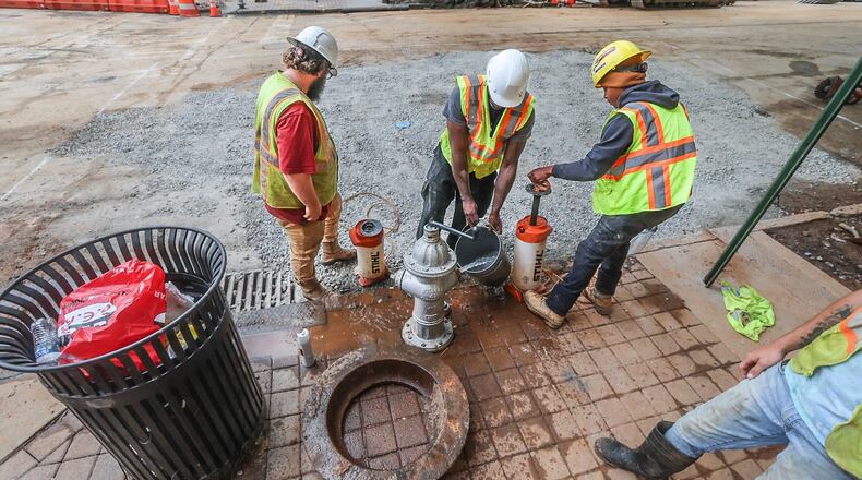 Crews covered a large hole at 11th and West Peachtree streets in Midtown as Mayor Andre Dickens announced Wednesday that water service has been restored.