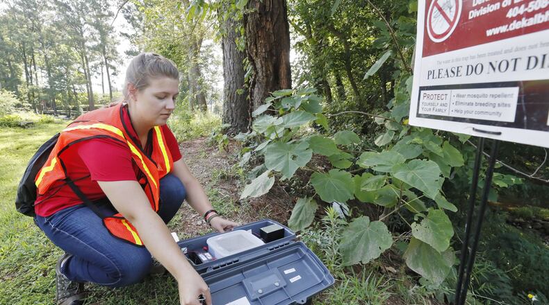 Callie Pierce, a seasonal staff member at DeKalb County Health Department’s Division of Environmental Health, checks a mosquito trap at Brookside Park. The mosquitoes in the trap were removed for testing. After a stretches of heavy rains, mosquitoes tend to multiply and this year testing is showing an unusually high number of mosquitoes testing positive for West Nile Virus. BOB ANDRES /BANDRES@AJC.COM AJC FILE PHOTO