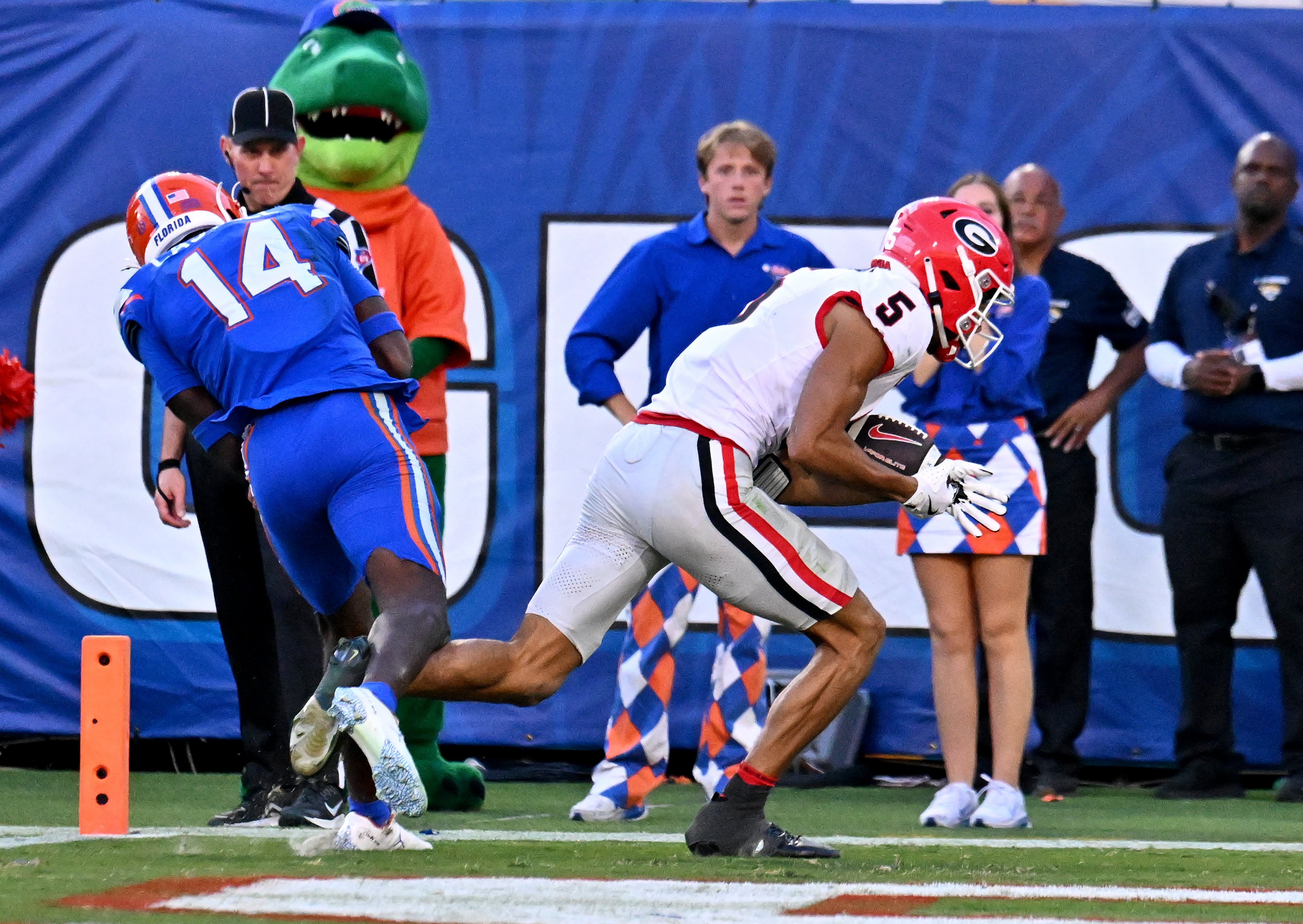 Georgia wide receiver Noah Thomas (5) falls after catching a touchdown pass over Florida safety Jordan Castell (14) during the second half in an NCAA football game, Saturday, November 1, 2025, Jacksonville, Fla. Georgia won 24-20 over Florida. (Hyosub Shin / AJC)