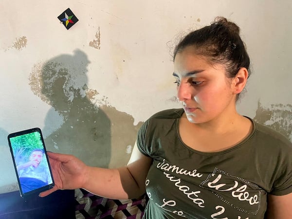 Druze woman, Evelyn Azzam, 20, shows a picture of her husband who was wounded in clashes between Syrian government forces and Druze militias in Sweida, during an interview with The Associated Press in the southern Damascus suburb of Jaramana, Wednesday, July 16, 2025. (AP Photo/Abdulrahman Shaheen)