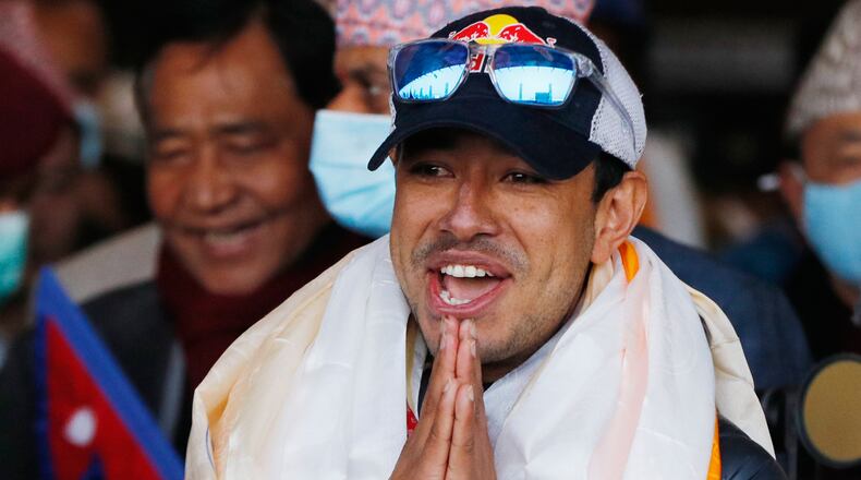 FILE - Nirmal Purja, one of the team member of the all-Nepalese mountaineering team that became the first to scale Mount K2 in winter, gestures as the team arrives at Tribhuwan International airport in Kathmandu, Nepal, Jan. 26, 2021. (AP Photo/Niranjan Shrestha, File)