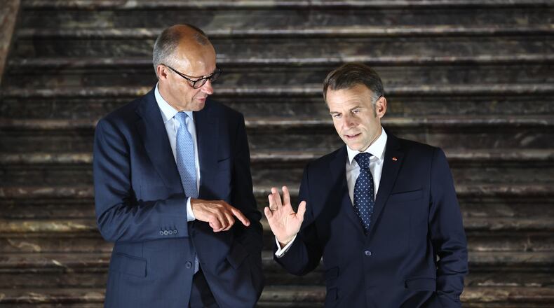 German Chancellor Friedrich Merz, left, talks with French President Emmanuel Macron as they arrive for a press conference following a meeting of the Franco-German Ministerial Council in Brühl, Germany, Friday, July 17, 2026. (Oliver Berg/dpa via AP)