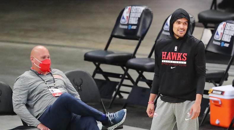 Hawks guard Trae Young laughs with general manager and team president Travis Schlenk before Game 5.  Young was not able to play. “Curtis Compton / Curtis.Compton@ajc.com”