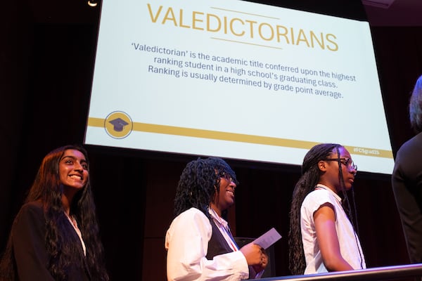 Danielle Kangnigan, center, valedictorian of Banneker High School, walks to the stage during the Senior Recognition Luncheon for Fulton County Schools. She will be going to NYU, in part because she thinks it will do a better job of protecting students' rights under the second Trump administration. (Ben Gray for the AJC)