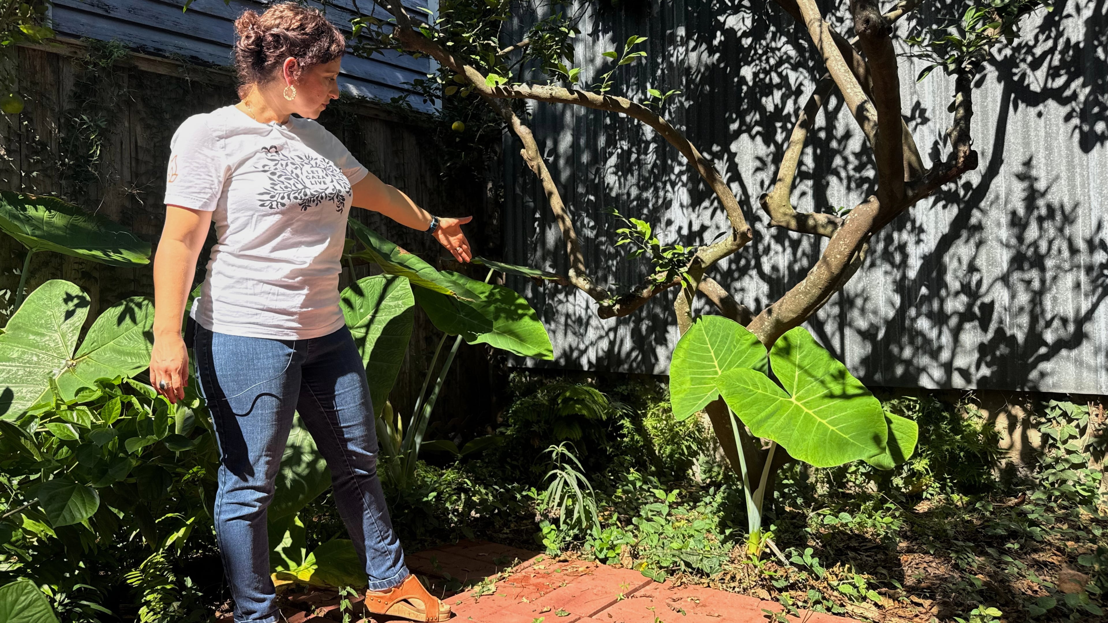 New Orleans resident Daniella Santoro points out the spot in her backyard where her family discovered a 1,900-year-old gravestone for a Roman sailor that had been missing for decades from an Italian museum, on Thursday, Oct. 9, 2025. (AP Photo/Jack Brook)