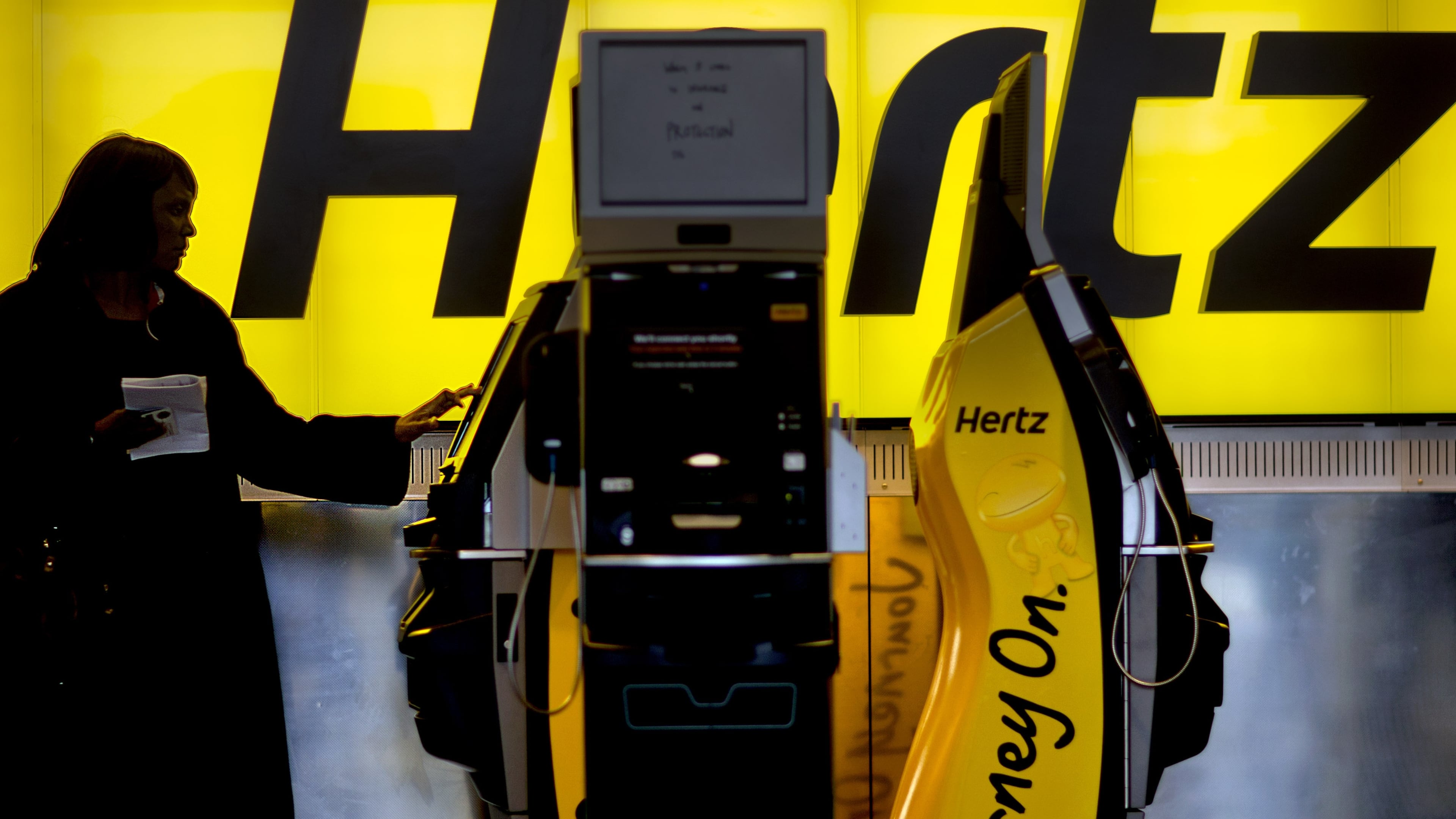 A customer checks in at a Hertz car rental counter at Hartsfield-Jackson Atlanta International Airport. Hertz has started deploying a vehicle inspection system called UVeye to determine damage to a returned car. (David Goldman/AP File)