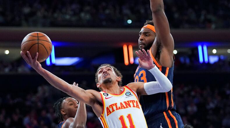 Atlanta Hawks guard Trae Young (11) goes to the basket against New York Knicks center Mitchell Robinson (23) during the first half of an NBA basketball game Wednesday, Dec. 7, 2022, at Madison Square Garden in New York. (AP Photo/Mary Altaffer)
