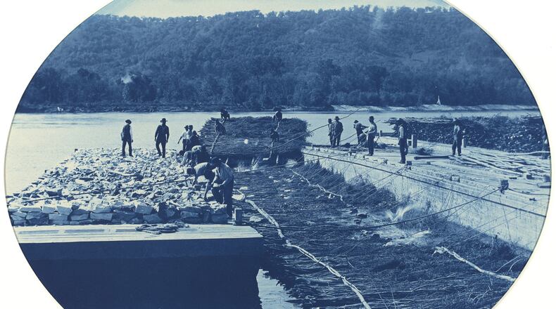 This photo from the National Gallery of Art and made available via the New Orleans Museum of Art, shows a cyanotype made in 1891 by Army Corps of Engineers employee Henry Peter Bosse, of construction of a rock and brush dam on the upper Mississippi River. The photograph is among more than 150 to be shown at the New Orleans Museum of Art in an exhibit of early U.S. landscapes east of the Mississippi. The exhibit originated at the National Gallery; New Orleans is its only other stop. (Henry Peter Bosse/Army Corps of Engineers via AP)