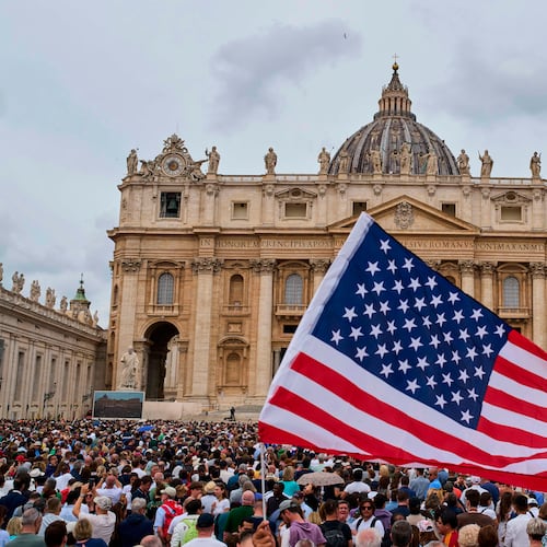 FILE - A flag from the United States waves in the crowd as Pope Leo XIV appears at the central balcony of St. Peter's Basilica for his first Sunday blessing after his election, in St. Peter's Square at the Vatican, Sunday, May 11, 2025. (AP Photo/Bernat Armangue, File)