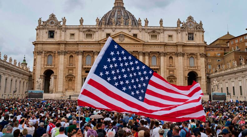 FILE - A flag from the United States waves in the crowd as Pope Leo XIV appears at the central balcony of St. Peter's Basilica for his first Sunday blessing after his election, in St. Peter's Square at the Vatican, Sunday, May 11, 2025. (AP Photo/Bernat Armangue, File)