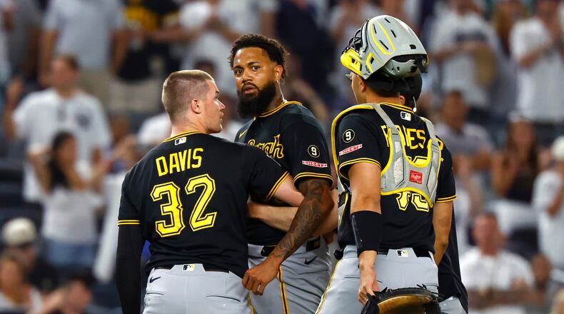 Pittsburgh Pirates catchers Henry Davis (32) and Rafael Flores Jr. keep pitcher Dennis Santana from going after New York Yankees' José Caballero during the ninth inning of a baseball game, Monday, July 20, 2026 in New York. (AP Photo/Noah K. Murray)