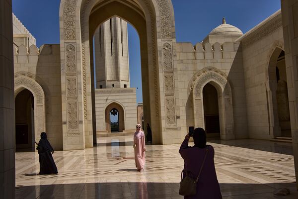 Tourists take photos at the Sultan Qaboos Grand Mosque in Muscat, Oman, Saturday, April 12, 2025. (AP Photo/ Fatima Shbair)