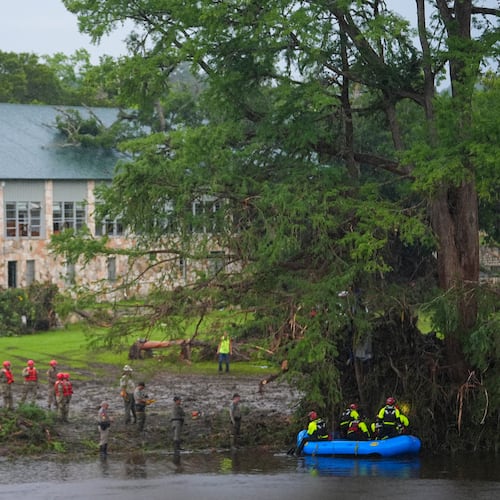 FILE - Rescue workers are seen on land and on a boat as they search for missing people near Camp Mystic along the Guadalupe River after a flash flood swept through the area Sunday, July 6, 2025, in Hunt, Texas. (AP Photo/Julio Cortez, File)