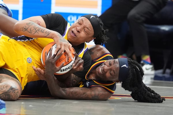 Los Angeles Sparks' Emma Cannon (32) and Indiana Fever's Natasha Howard (6) batlle for a loose ball during the second half of a WNBA basketball game, Saturday, July 5, 2025, in Indianapolis. (AP Photo/Michael Conroy)