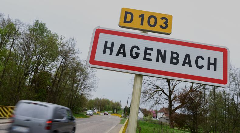 A car drives past a road sign at the entrance of Hagenbach where a 9-year-old boy was rescued this week after living locked in his father's utility van since 2024, Eastern France, Saturday, April 11, 2026. (AP Photo)