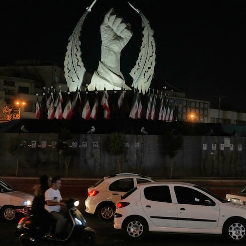 Vehicles drive past a monument depicting the clenched fist of the late Iranian Supreme Leader Ayatollah Ali Khamenei, who was killed in the U.S. and Israel strike on Feb. 28, in Islamic Revolution Square in Tehran, Sunday, July 19, 2026. (AP Photo/Vahid Salemi)
