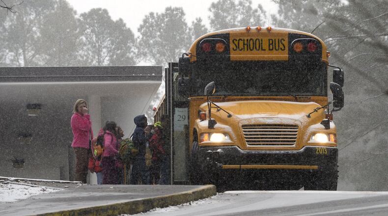 Sagamore Hills Elementary School students board a DeKalb County school bus for early dismissal as a major winter storm dumps 1 to 3 inches of snow on the metro Atlanta area, Tuesday, Jan. 28, 2014. David Tulis / AJC Special