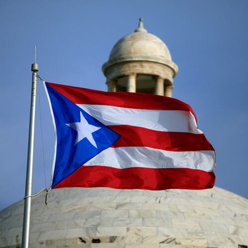 FILE - A Puerto Rican national flag flies in front of the Capitol building in San Juan, Puerto Rico, July 29, 2015. (AP Photo/Ricardo Arduengo, File)