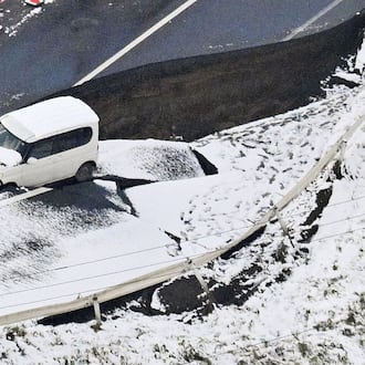 This aerial photo shows a vehicle sitting on a damaged road in Tohoku town, Aomori prefecture, northern Japan Tuesday, Dec. 9, 2025, following a powerful earthquake on late Monday. (Kyodo News via AP)