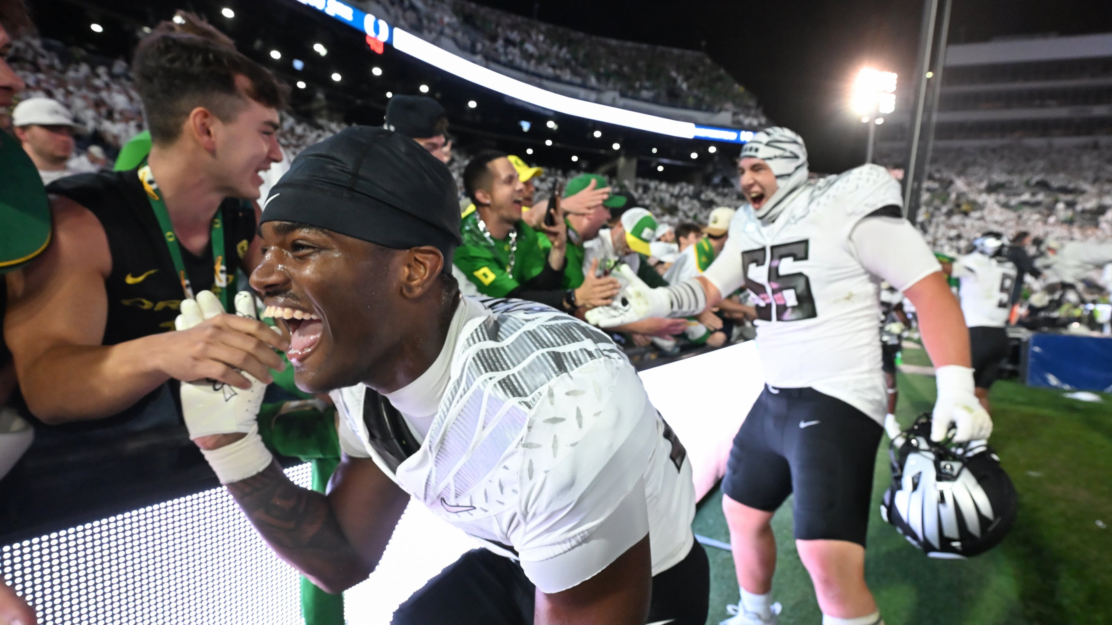 Oregon linebacker Nasir Wyatt (32) and Oregon offensive lineman Trent Ferguson (56) celebrate their second overtime win over Penn State during their NCAA college football game, Saturday, Sept. 27, 2025, in State College, Pa. (AP Photo/Barry Reeger)