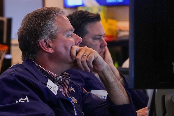 Trader Thomas McCauley, left, works on the floor of the New York Stock Exchange, Tuesday, July 8, 2025. (AP Photo/Richard Drew)