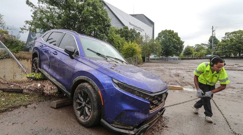 September 15, 2023 Atlanta: A-Tow driver Tobias Brown readies to tow a lone Honda vehicle carried by flood waters into a church parking lot fence at Central United Methodist Church located at 501 M.L.K. Jr. Drive SW, in Atlanta sat idle Friday morning, Sept. 15, 2023 hours after flash flood water inundated the downtown area. At the Central United Methodist Church, which sits in the shadow of massive Mercedes-Benz Stadium, Rev. Vance P. Ross looked on as tow truck drivers fished flooded vehicles out of his parking lot. Ross spent much of the morning on the phone with the insurance company after Thursday’s storm flooded his congregation’s fellowship hall. Mud lines on the door of the church show at least four feet of water gushed through the building. Two vehicles parked in the lot down the hill were pushed around like boats, Ross said, and a large dumpster ended up floating about 50 yards away during the storm. A blue Honda SUV got washed into a fence and quickly filled with rainwater, likely totaling the vehicle. The father and son who were inside managed to get out safely. Luckily, nobody was injured or killed, the pastor said. As for the property damage, Ross said most things can be fixed or replaced. ”Water is life-giving, but it can also be life-taking,” the pastor said. “We’re not the only ones to be flooded in recent days. The first step is to clean up and assess the damage.” Strong and quick-moving thunderstorms plowed through downtown Atlanta on Thursday afternoon, flooding roads, impacting college students and prompting the evacuation of one of the city’s premier attractions. According to city officials, rain gauges show that about three hours’ worth of rain came down in just 15 minutes in some areas of downtown Atlanta. (John Spink / John.Spink@ajc.com)