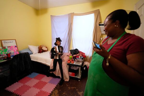 Crystal Holmes, right, talks with her granddaughter, Mackenzie Holmes, 10, in their room at Mission of Yahweh women's shelter after school on Tuesday, April 1, 2025, in Houston. (AP Photo/Ashley Landis)