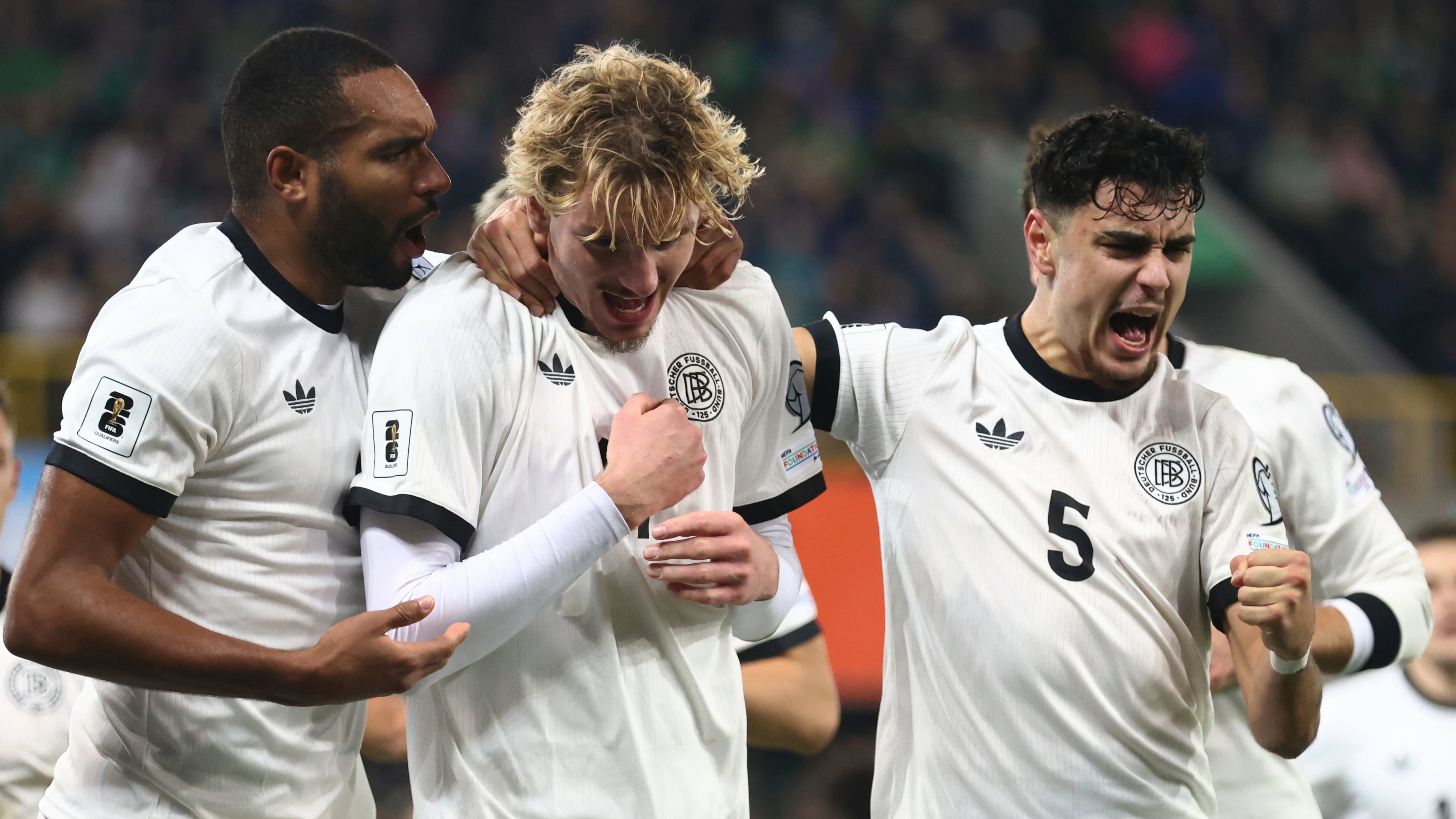 Germany's Nick Woltemade, center, celebrates with teammates Aleksandar Pavlovic, right, and Jonathan Tah, after scoring the opening goal of his team during the World Cup 2026 group A qualifying soccer match between Northern Ireland and Germany at Windsor Park stadium, in Belfast, Northern Ireland, Monday, Oct. 13, 2025. (AP Photo/Peter Morrison)