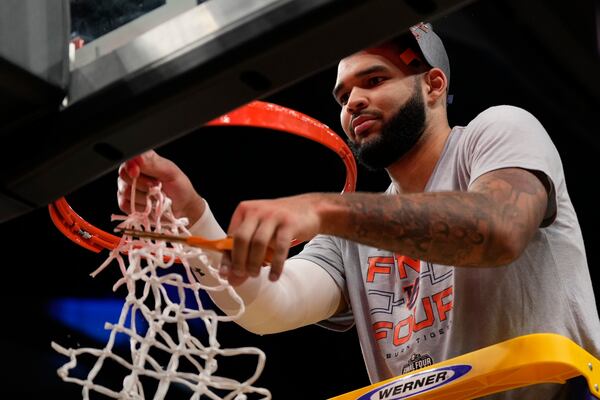 Auburn forward Johni Broome (4) cuts the net after the Elite Eight of the NCAA college basketball tournament against Michigan State, Sunday, March 30, 2025, in Atlanta. (AP Photo/George Walker IV)
