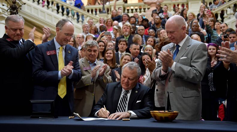 April 16, 2015 Atlanta, GA: Gov. Nathan Deal signs House Bill 1 Thursday amid a crowd of supporters. The bill now allows the limited use of cannabis oil to treat disorders that include cancer, sickle cell disease and epilepsy as long as a physician signs off. BRANT SANDERLIN/BSANDERLIN@AJC.COM Gov. Nathan Deal signs House Bill 1 Thursday amid a crowd of supporters. BRANT SANDERLIN/BSANDERLIN@AJC.COM