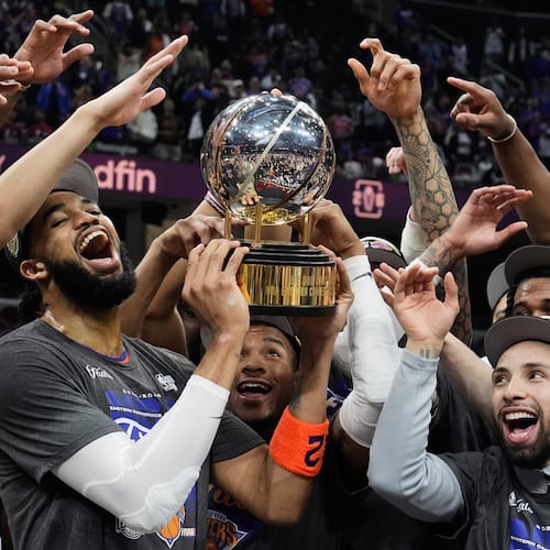 New York Knicks center Karl-Anthony Towns, center, and teammates celebrate after winning Game 4 in the Eastern Conference finals NBA basketball playoffs series against the Cleveland Cavaliers in Cleveland, Monday, May 25, 2026. (AP Photo/Sue Ogrocki)