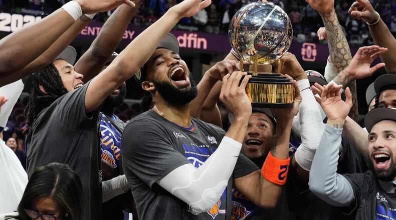 New York Knicks center Karl-Anthony Towns, center, and teammates celebrate after winning Game 4 in the Eastern Conference finals NBA basketball playoffs series against the Cleveland Cavaliers in Cleveland, Monday, May 25, 2026. (AP Photo/Sue Ogrocki)