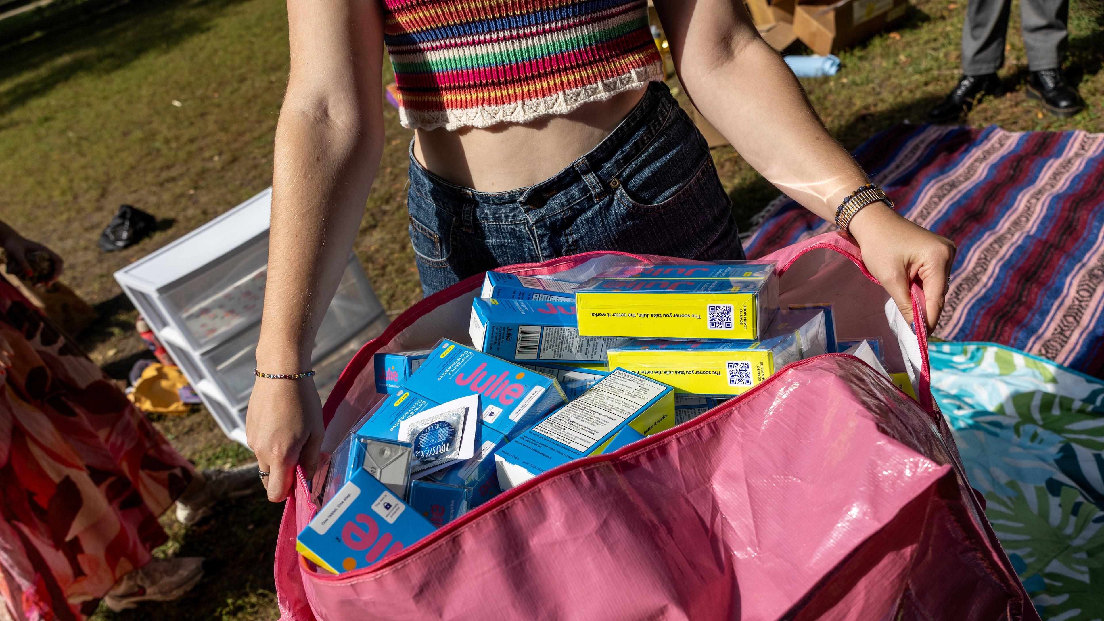 A DePaul University student carries a bag of contraceptive supplies at Oz Park in Chicago on Sunday, Sept. 28, 2025. (AP Photo/Heidi Zeiger)