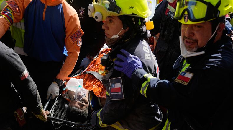 Chilean rescue workers carry Hernán Alberto Gil Flores after he was pulled from the rubble eight days after he was trapped by twin earthquakes that struck Catia La Mar, Venezuela, Thursday, July 2, 2026. (AP Photo/Fernando Vergara)
