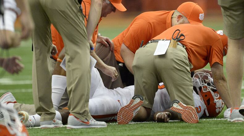 Clemson quarterback Kelly Bryant lies on the field and is attended to by team staff after suffering a concussion during a game earlier this year against Syracuse. Clemson is one of the ACC schools that reported to the AJC that it tracks concussions by sport. Photo by Adrian Kraus/Associated Press.
