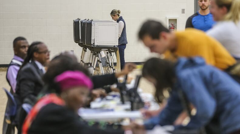 Georgia saw lighter turnout for the runoff on Dec. 4, when these voters were casting ballots at Henry W. Grady High School in Atlanta. The runoff settled two statewide races — for secretary of state and a seat on the Public Service Commission — after no candidate won a majority in either of those races during the November general election. JOHN SPINK/JSPINK@AJC.COM
