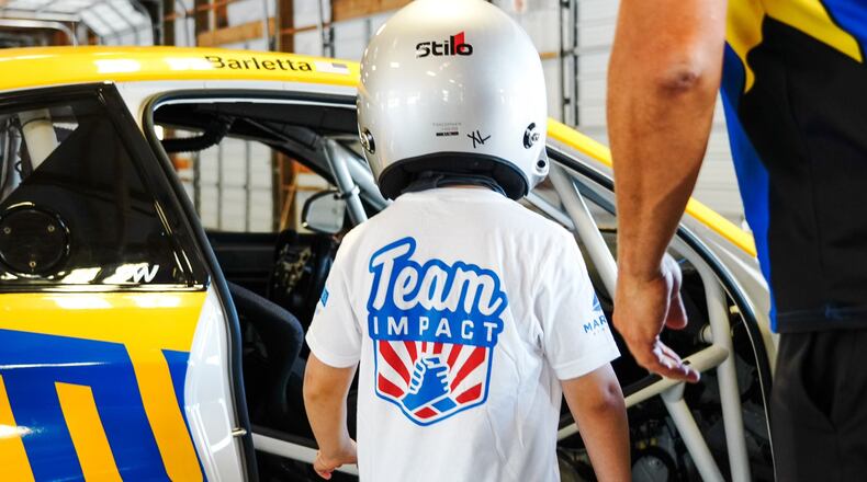 A Team IMPACT-matched child prepares for their turn racing on the Thompson Speedway track in Thompson, Connecticut, with a professional racecar driver. (Courtesy Team IMPACT)
