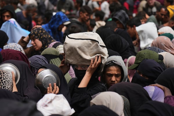 Palestinians wait for donated food at a distribution center in Nuseirat, central Gaza Strip, Wednesday, April 30, 2025. (AP Photo/Abdel Kareem Hana)