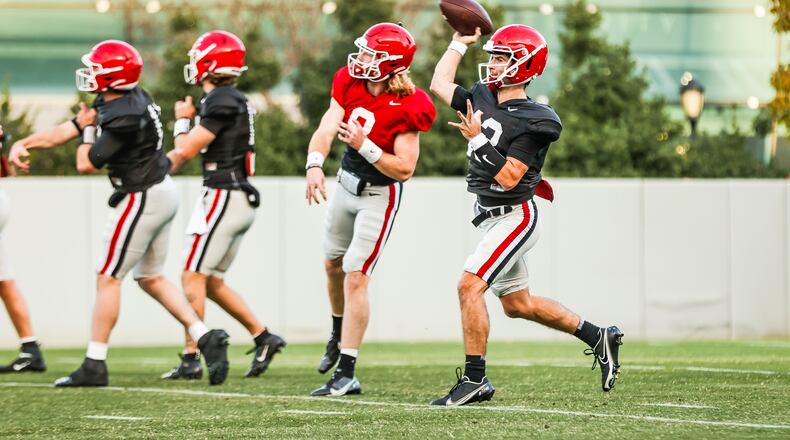 Georgia's quarterbacks, including senior starter Stetson Bennett (right), warm up early in practice on Tuesday, Nov. 16, 2021 at Woodruff Practice Fields (Photo by Tony Walsh/UGA Athletics)