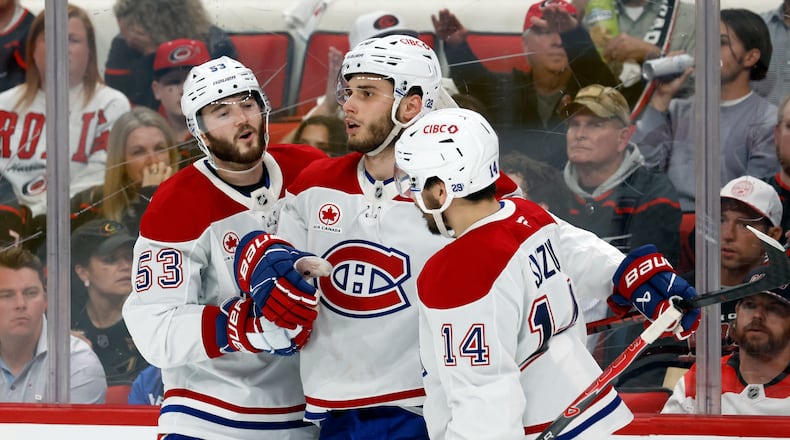 Montréal Canadiens' Juraj Slafkovský (20), center, celebrates his goal with Nick Suzuki (14) and Noah Dobson (53) during the third period in Game 1 of the Eastern Conference finals NHL hockey Stanley Cup playoffs series against the Carolina Hurricanes in Raleigh, N.C., Thursday, May 21, 2026. (AP Photo/Karl DeBlaker)
