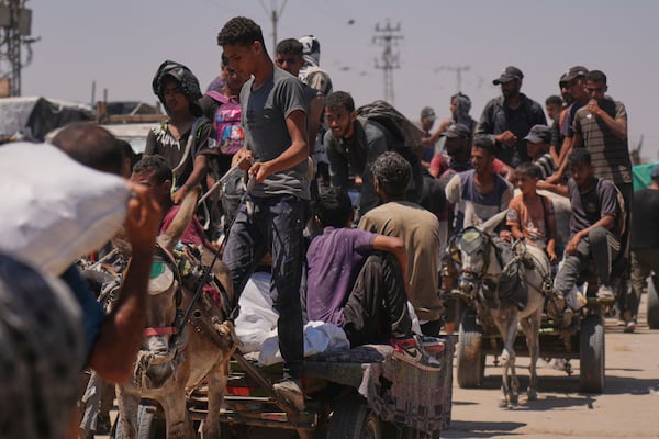 Palestinians carry bags containing food and humanitarian aid packages delivered by the Gaza Humanitarian Foundation, a U.S.-backed organization, in Rafah, southern Gaza Strip, Wednesday, June 25, 2025. (AP Photo/Abdel Kareem Hana)