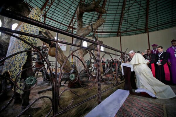 FILE - Pope Francis kneels in prayer during his visit at the Anglican martyrs' shrine of Namugongo, Kampala, Uganda, Saturday, Nov. 28, 2015. (AP Photo/Andrew Medichini, Pool, file)
