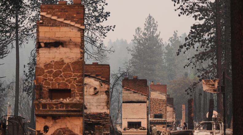 Chimneys are the only structures remaining in a residential neighborhood after a wildfire hit the northern part of Spokane, Wash., Monday, Aug. 3, 2026. (AP Photo/Lindsey Wasson)