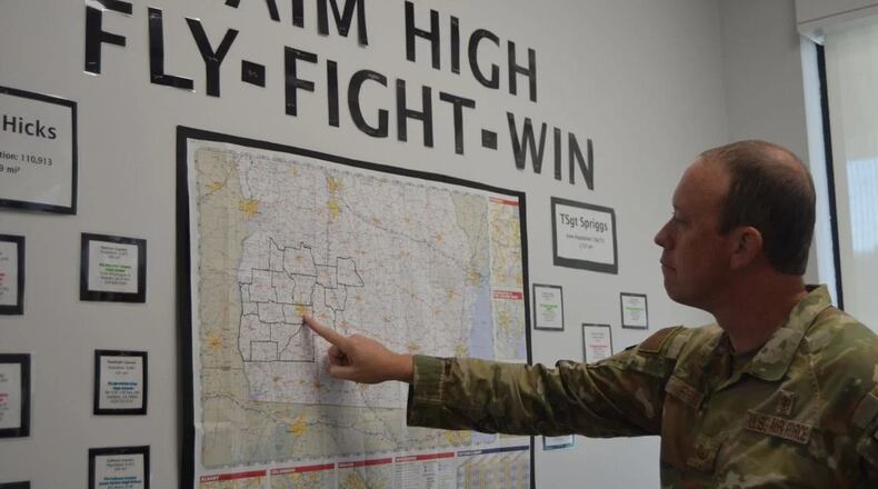 U.S. Air Force Tech Sgt. Payden Forkum points out some of the territory he serves on a map located in the recruitment office on North Westover Boulevard. (Photo Courtesy of Alan Mauldin)