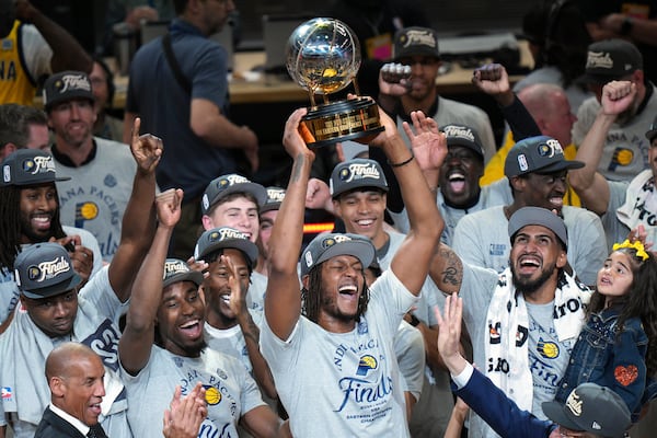 Indiana Pacers center Myles Turner holds the trophy as players celebrate after winning Game 6 of the Eastern Conference finals of the NBA basketball playoffs against the New York Knicks in Indianapolis, Saturday, May 31, 2025. (AP Photo/AJ Mast)