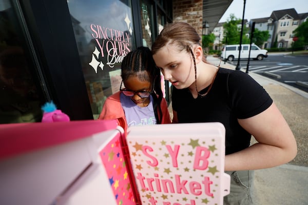 Fifth graders and classmates Emely Birkinbine (11), right, and Dinah Miller (11) are seen selecting their trinkets, ready to exchange outside the Sincerely Yours bookstore in Smyrna on Wednesday, April 29, 2026. (Miguel Martinez/AJC)