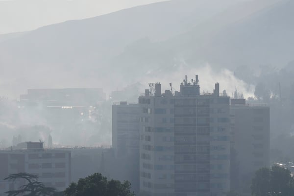 Smoke rises behind buildings during wildfire Tuesday, July 8, 2025 in La Catellane district of Marseille, southern France. (AP Photo/Lewis Joly)